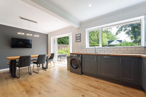 a kitchen and dining room with a washer and dryer at Coastal Garden Retreats in Poole