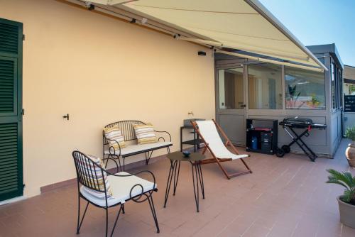 a patio with chairs and a table and an umbrella at Maison Hublot in Chiavari