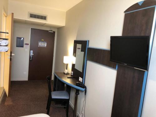 a hotel room with a desk with a computer and a television at BRAUCOL Hotel in Brens