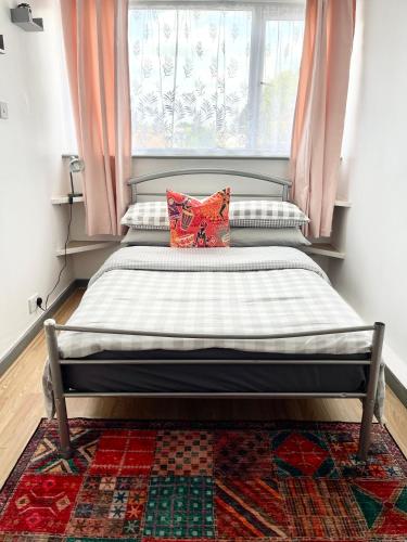 a bed in a bedroom with a window at 12 Penn Gardens- Apart 2 in Friern Barnet