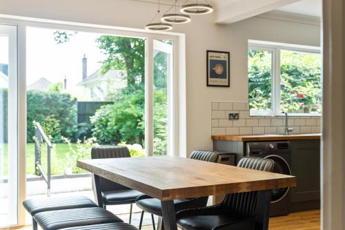 a kitchen with a wooden table and chairs at Coastal Garden Retreats in Poole