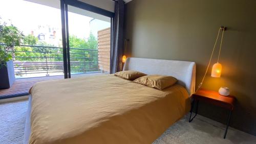 un lit dans une chambre avec une grande fenêtre dans l'établissement La Douceur Tourangelle, à Tours