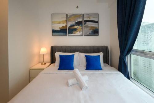 a bedroom with a bed with blue pillows and a window at 2R2B Seaview Serenity 1 to 8pax Gurney Mansion One in George Town