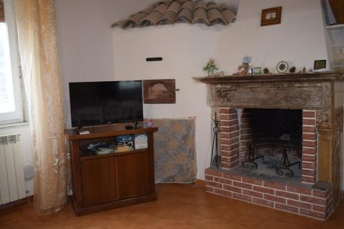 a living room with a fireplace with a flat screen tv at Guado di Pio-appartamento panoramico in Castelpetroso