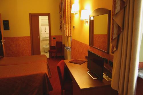 a hotel room with a desk with a computer on it at Hotel Majestic in San Giuliano Milanese