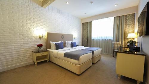 a hotel room with a large bed with blue pillows at Sapphire Marine in Baku