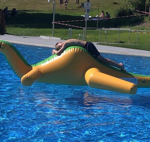 a man is laying on a raft in a pool at Ferienwohnung Schneemann in Hohegeiß