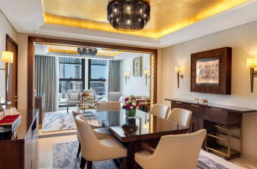 a dining room and living room with a table and chairs at The Oberoi Madina المدينة أوبروي in Al Madinah