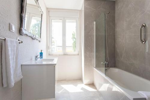 a bathroom with a tub and a sink and a shower at Near the River 3 Bedrooms Flat, with AC for 9 in Lisbon