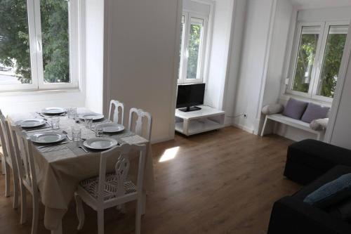 a white dining room with a table and chairs at Near the River 3 Bedrooms Flat, with AC for 9 in Lisbon