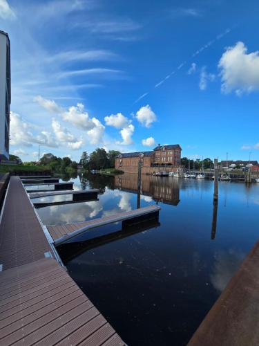 a view of a river with buildings and a blue sky at Ferienappartment Weisse Düne in Norden