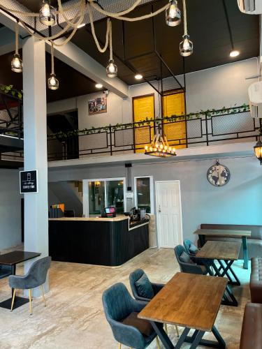 a lobby with tables and chairs and a counter at Friends Station Tukkom Hostel & Cafe in Pattaya South
