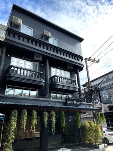 a black building with plants on the side of it at Friends Station Tukkom Hostel & Cafe in Pattaya South