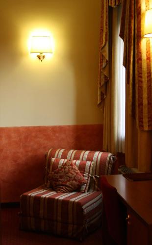 a living room with a couch and a lamp at Hotel Majestic in San Giuliano Milanese