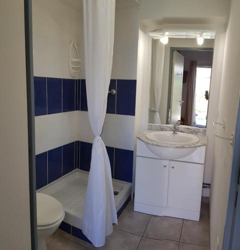 une salle de bain avec un lavabo, des toilettes et un miroir dans l'établissement maisonnette de vacance dans résidence avec piscine à 12m des plages, à Colombiers