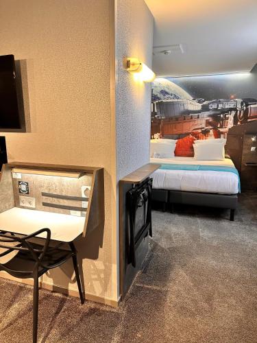 a room with a bed and a desk with a tv at Hôtel Kyriad Rennes Centre Gare in Rennes