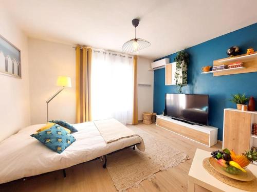 une chambre avec un grand lit et une télévision dans l'établissement T2 cosy Toulon, proche plage, à Toulon