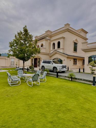 a group of lawn chairs in front of a house at Emerald Villa Swat in Ghurejo