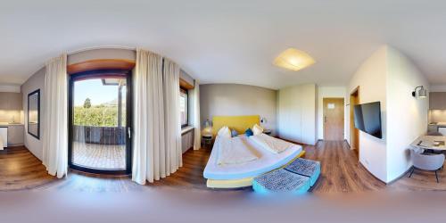 a room with a bed and a television in it at Feldgärtenhof in Silandro