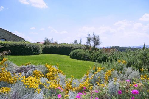a garden with colorful flowers and bushes at Podere Il Pino in Poggibonsi