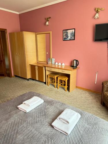 a room with a bed with two towels on it at Лелеч in Tatariv