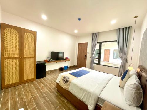 a bedroom with a bed and a television in it at Khải Hoàn Luxury Hotel in Bến Cát