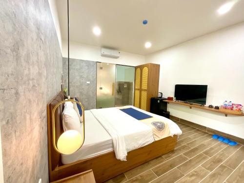a bedroom with a bed and a television in it at Khải Hoàn Luxury Hotel in Bến Cát