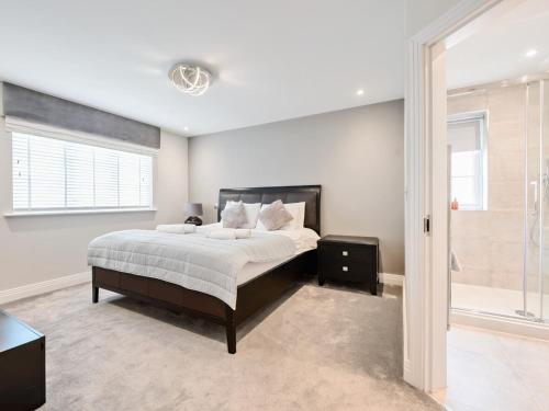 a bedroom with a large bed and a window at Pass The Keys Stunning 5 Bedroom Spacious Home in Bookham