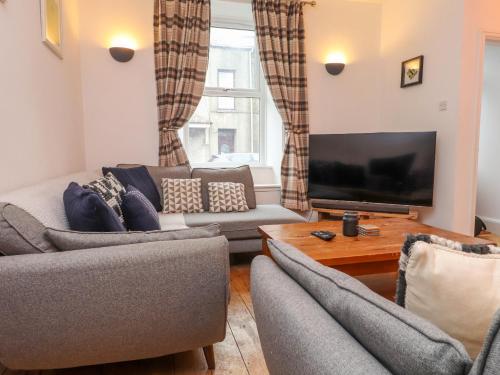 a living room with two couches and a flat screen tv at Heol Madog in Porthmadog