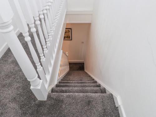 a staircase with white railings in a house at Heol Madog in Porthmadog