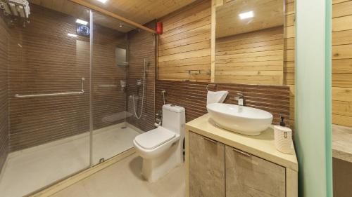a bathroom with a toilet and a sink and a shower at The Arowana Divine in Nānded
