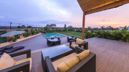 an outdoor deck with furniture and a swimming pool at The Arowana Divine in Nānded