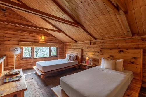 a bedroom with two beds in a log cabin at Alaya Stays Duplex Cottage with Tree House - Suro Woodcrest Chalet in Shogi