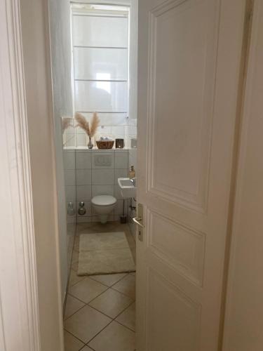 a bathroom with a toilet and a window and a door at Altbau-Oase der Eleganz: Stadtnaher Komfort pur in Wiesbaden