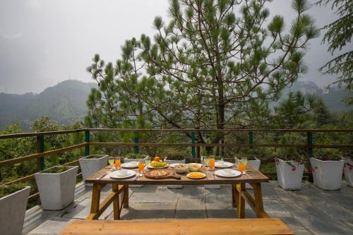 a wooden table with food on top of a balcony at Alaya Stays Duplex Cottage with Tree House - Suro Woodcrest Chalet in Shogi