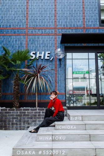 a man sitting on the steps in front of a building at Hotel She, Osaka in Osaka