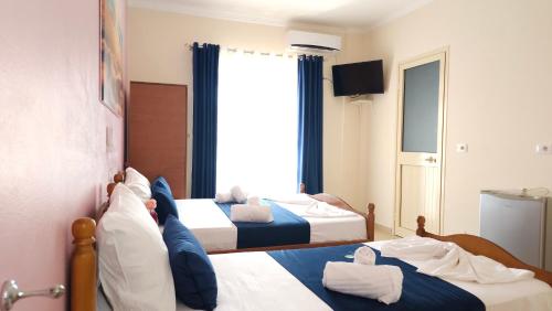 a hotel room with two beds and a window at Friends House - Borsh Hotel in Borsh