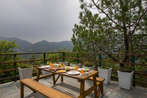 a wooden table with food on top of a balcony at Alaya Stays Cottage with Tree House - Suro Woodbine Chalet in Shogi