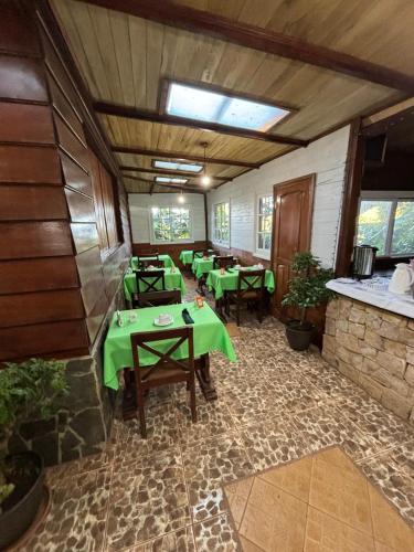 a restaurant with green tables and chairs in a room at Hotel Bosque Verde Lodge in Monteverde Costa Rica