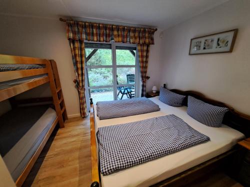a bedroom with two bunk beds and a window at Appartementhaus am Fichtelberg in Kurort Oberwiesenthal