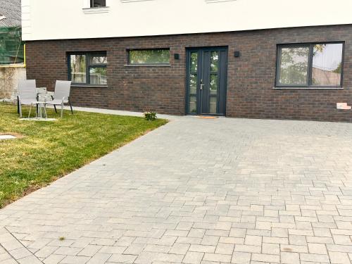 a brick building with chairs and a patio at Apartament modern in Vila, cu curte proprie la 2km de centrul Sucevei in Ipoteşti
