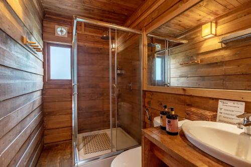 a bathroom with a shower and a sink at Alaya Stays Cottage with Tree House - Suro Woodbine Chalet in Shogi