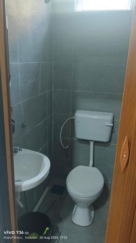 a bathroom with a toilet and a sink at Andalus Cottage in Wakaf Baharu
