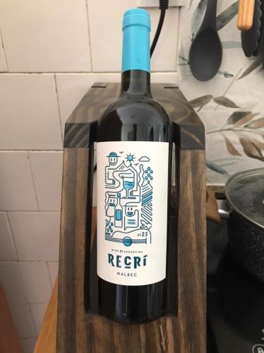a bottle of red wine sitting on a cutting board at Brás, Expo Center Norte, Vinho e Estacionamento Gráris, até 7 pessoas, Cozinha, ao lado do polo compras, tiers, valtier, feirinha in Sao Paulo