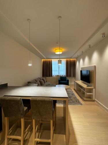 a living room with a dining table and a couch at Apartmani Zepterme by CENTRAL in Vrnjačka Banja