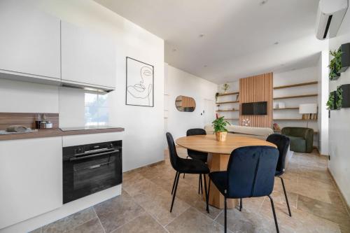 a kitchen and dining room with a table and chairs at Résidence Jaures - Appartements design et climatisés en centre ville in Vichy