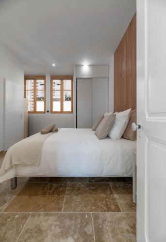 a bedroom with a large bed with white sheets at Résidence Jaures - Appartements design et climatisés en centre ville in Vichy