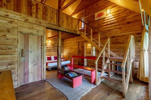 a room with a bunk bed and stairs in a log cabin at Alaya Stays Duplex Cottage with Tree House - Suro Woodcrest Chalet in Shogi