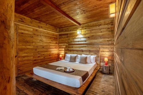 a bedroom with a bed in a wooden cabin at Alaya Stays Duplex Cottage with Tree House - Suro Woodcrest Chalet in Shogi