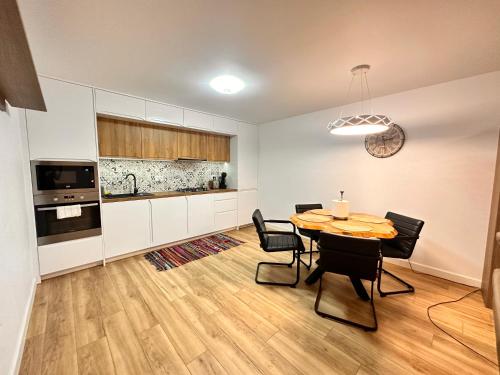 a kitchen and dining room with a table and chairs at Apartament modern in Vila, cu curte proprie la 2km de centrul Sucevei in Ipoteşti